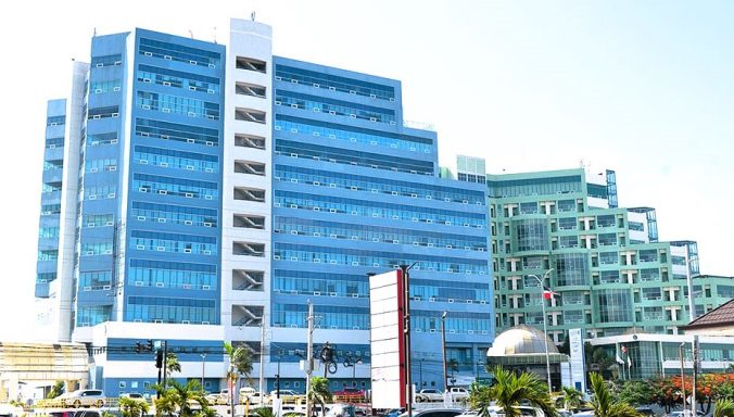 Klinik  mit großen Glasfassaden und hellem Himmel im Hintergrund.
